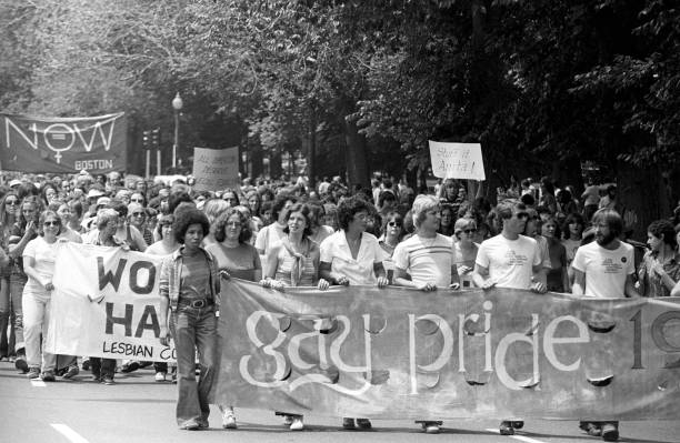 View of the large crowd, some of whom are holding up handmade signs and banners, participating in a gay and lesbian pride parade in the Back Bay neighborhood of Boston, 1975. (Photo by Spencer Grant/Getty Images)
